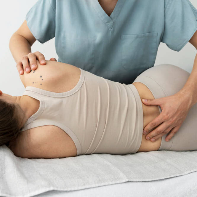 A therapist providing a back massage to a client on a treatment table.